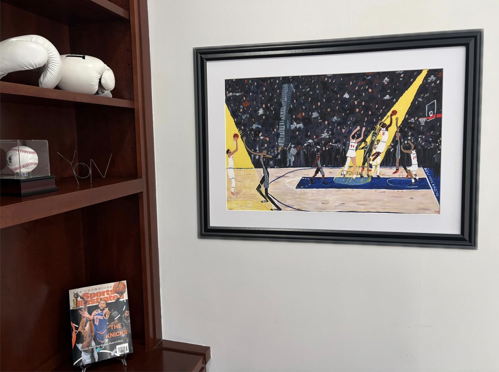 “IT’S GOOD! IT’S GOOD! IT’S GOOD!” print framed in black with a white mat, hanging above a shelf